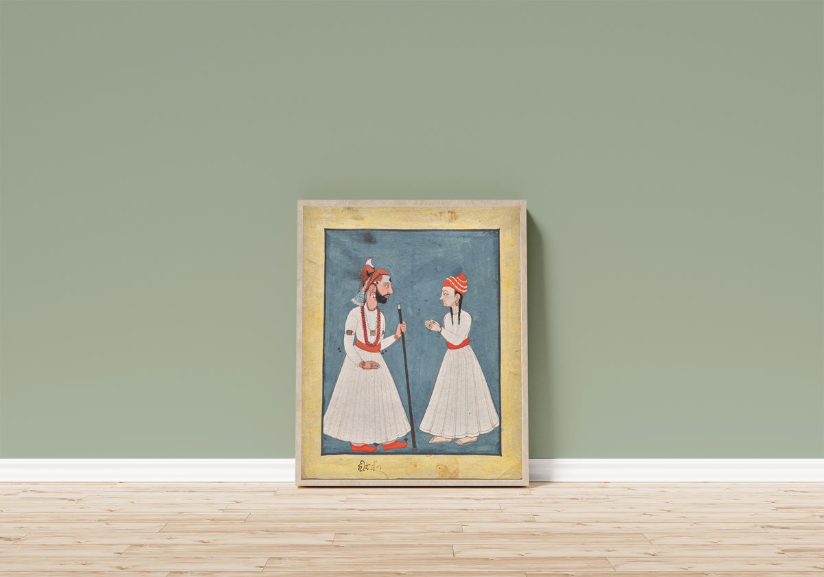 Framed art print of Shamsher Sen of Mandi with a youth by Mandi school, in a light wood frame leaning on a sage green wall above a wooden floor
