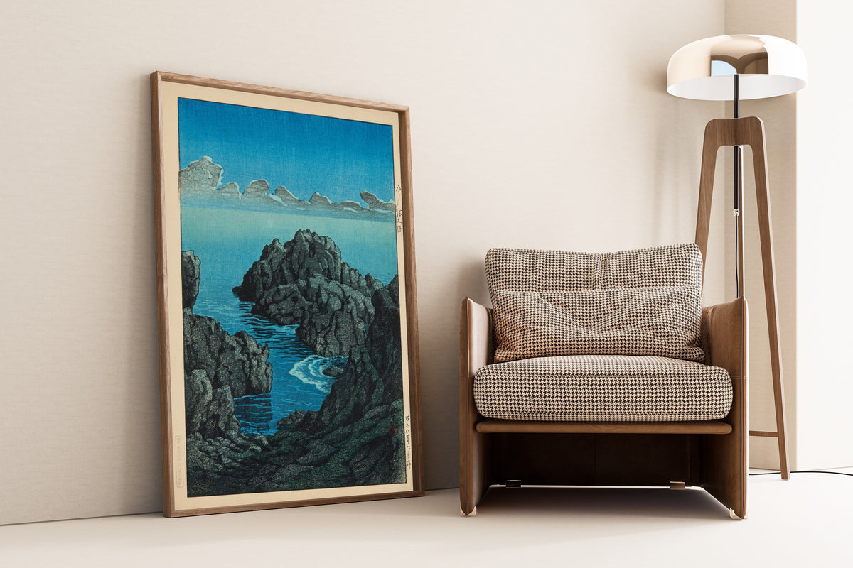 Framed art print of Shinkubo, Hachinohe by Kawase Hasui, leaning against a wall beside an armchair and a floor lamp