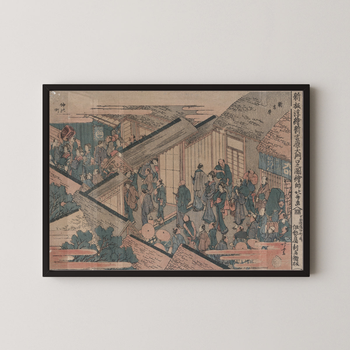 Framed art print of Shinpan ukie shin yoshiwara ōmonuchi no zu by Katsushika Hokusai, in a black frame on a pale wall