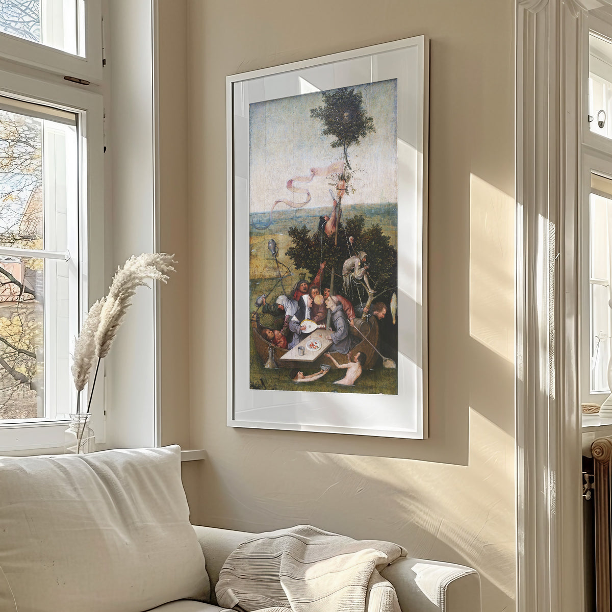 Framed art print of Ship of Fools by Hieronymus Bosch, in a sunlit living room above a sofa
