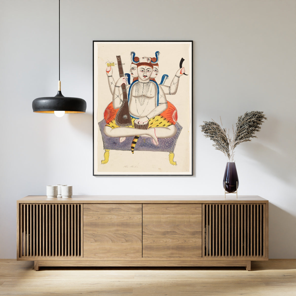 Framed art print of Shiva by Kalighat painter, above a slatted wood sideboard