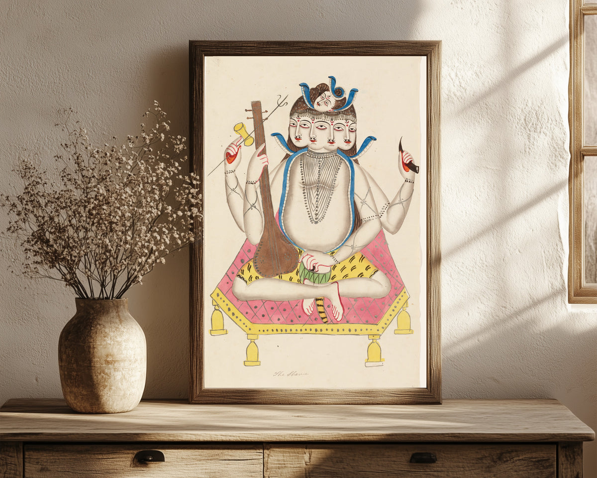 Framed art print of Shiva with Five Faces by Kalighat painter, in a dark wood frame leaning on a rustic console beside dried flowers