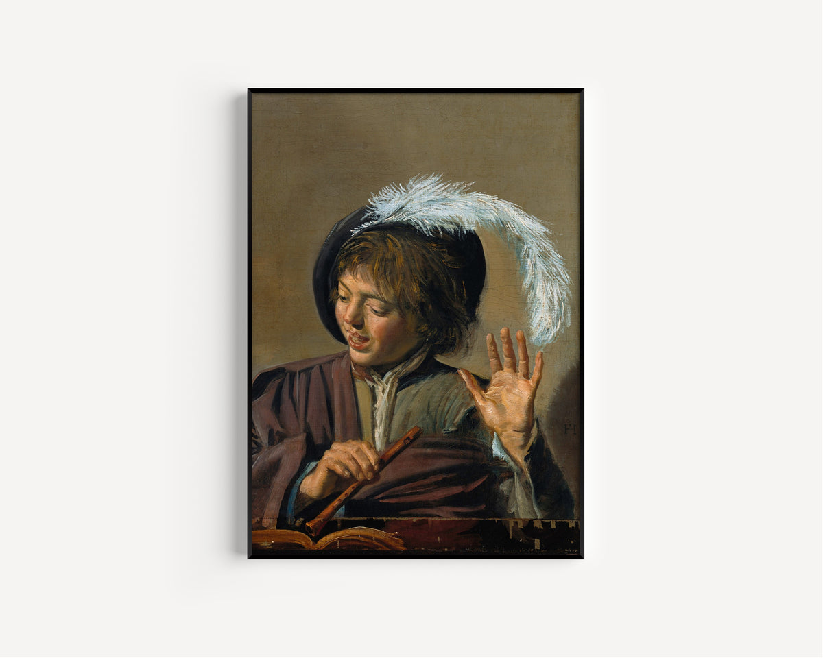 Framed art print of Singing Boy with Flute by Frans Hals, in a slim black frame on a plain white wall