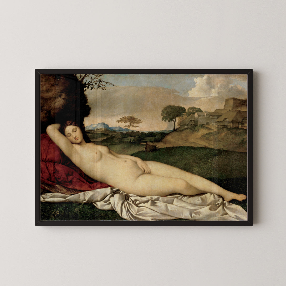 Framed art print of Sleeping Venus by Giorgione, in a black frame on a pale wall