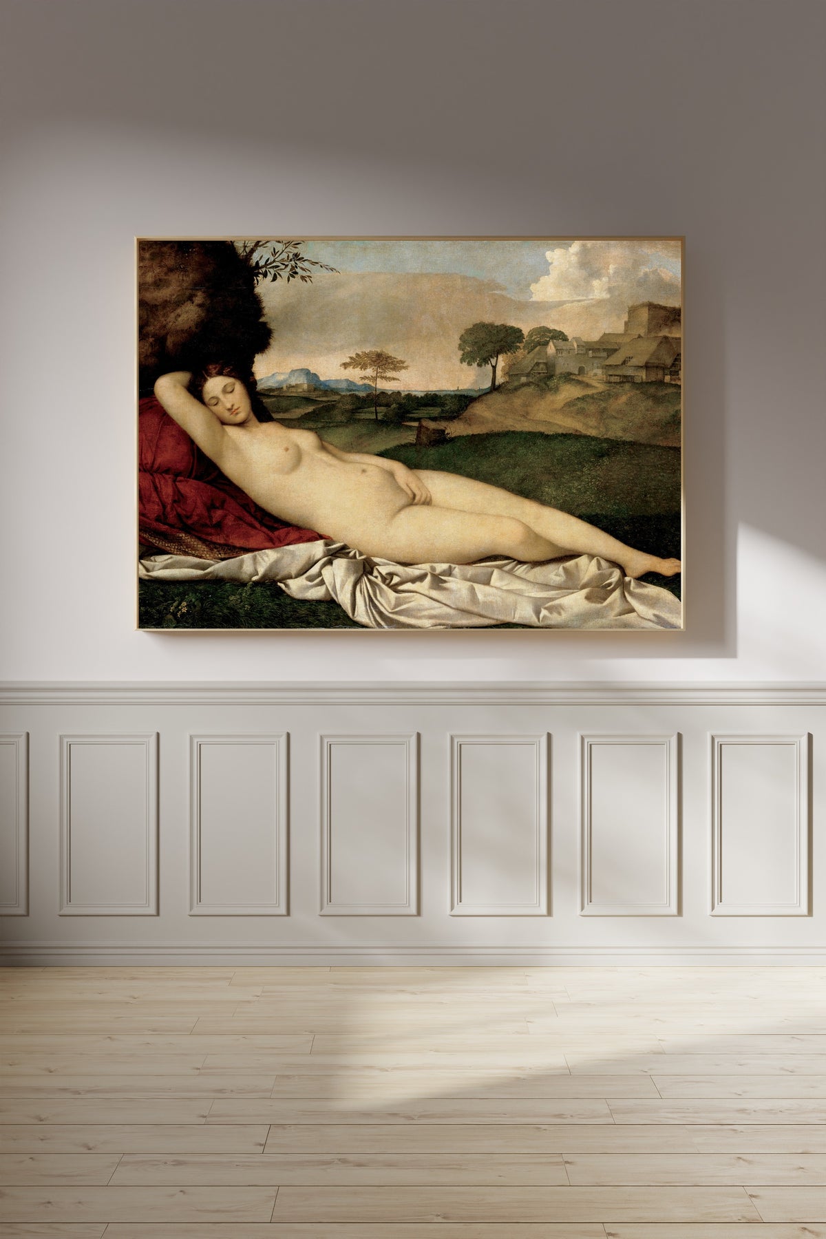Framed art print of Sleeping Venus by Giorgione, on a panelled wall in afternoon light