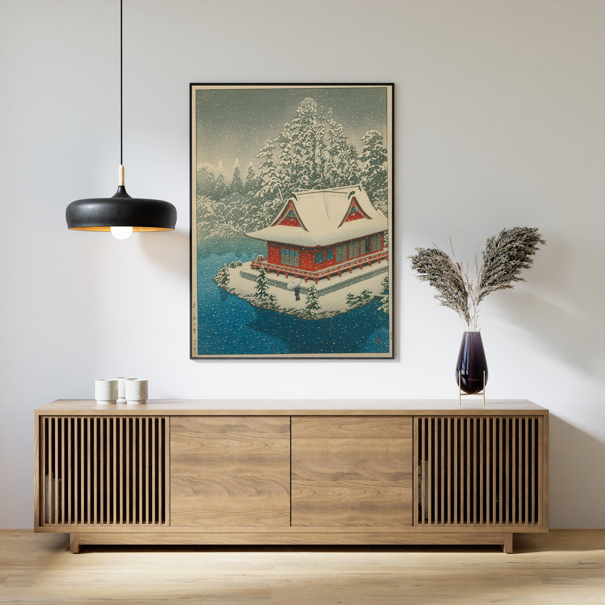 Framed art print of Snow at Inokashira by Kawase Hasui, above a slatted wood sideboard