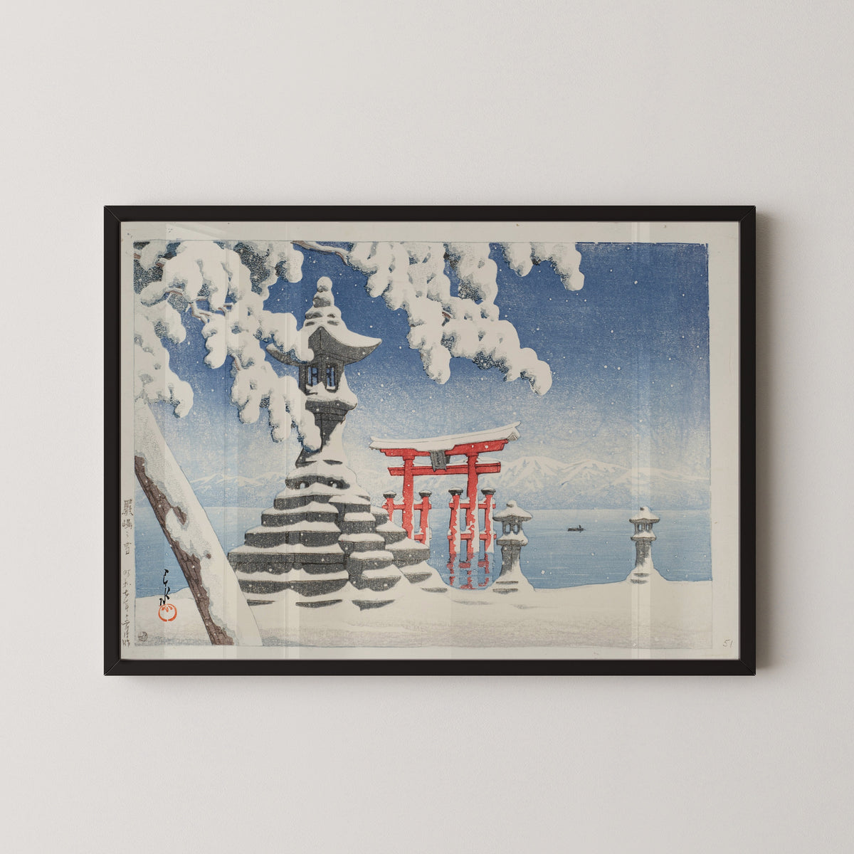 Framed art print of Snow at Itsukushima by Kawase Hasui, in a black frame on a pale wall