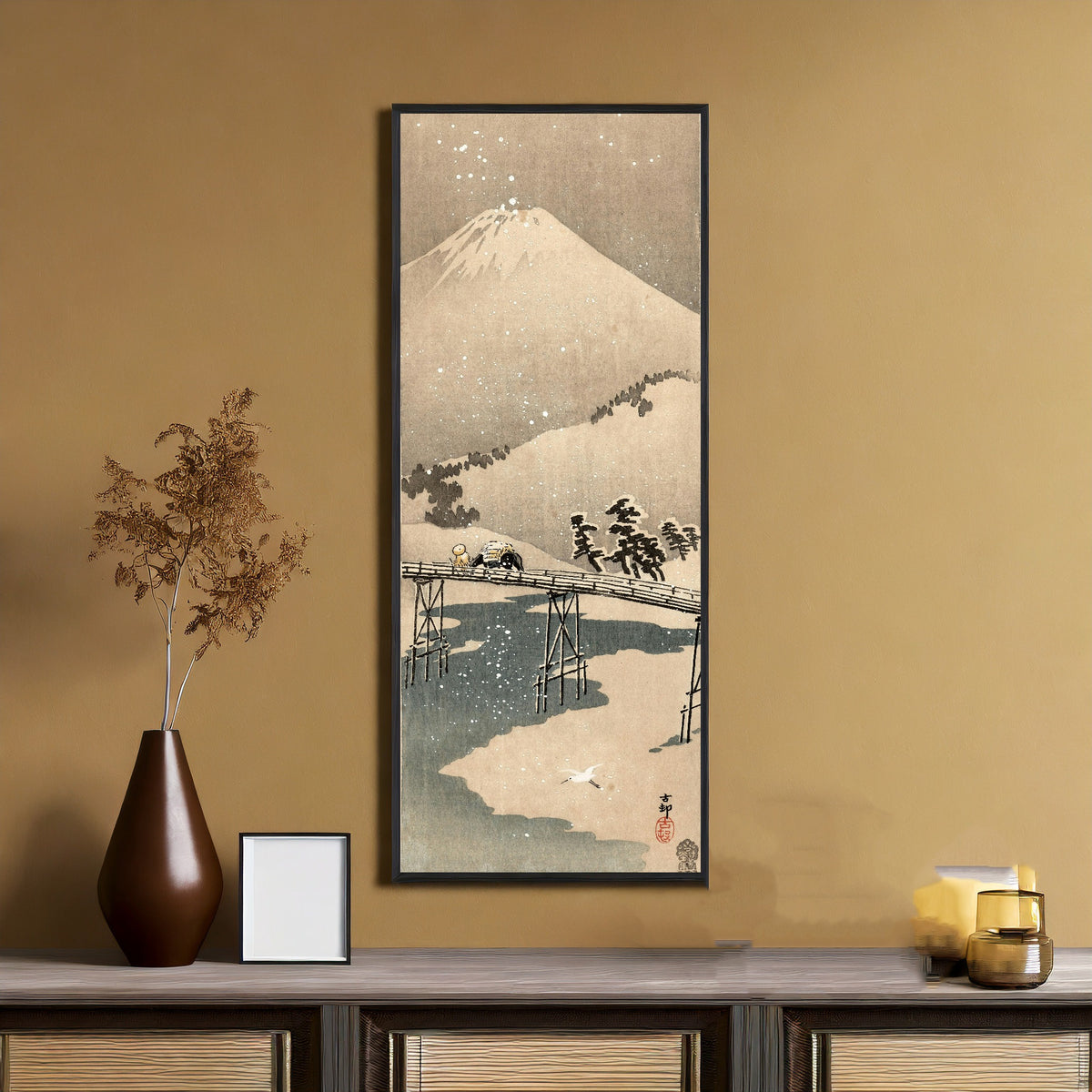 Framed art print of Snowy Landscape with Mount Fuji by Ohara Koson, on an ochre wall above a console table