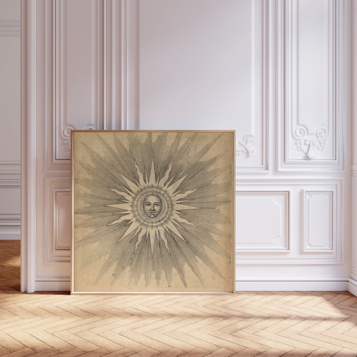 Framed art print of Solis: the Sun with a Face (Utriusque Cosmi, p. 19) by Robert Fludd, leaning against pale pink panelling on a herringbone floor