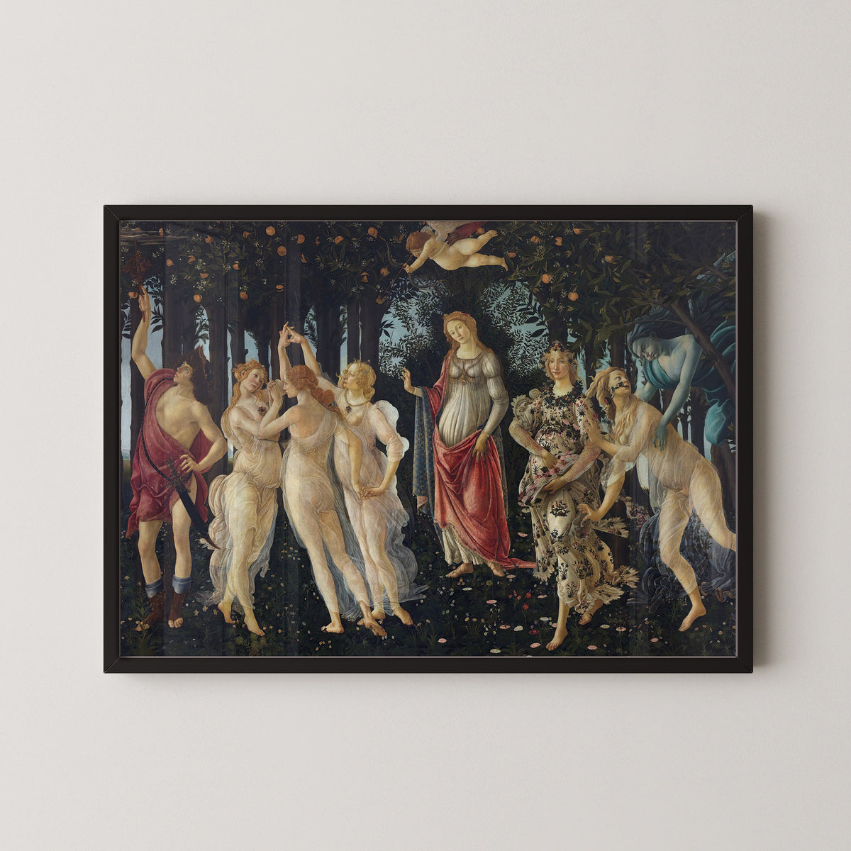 Framed art print of Spring by Sandro Botticelli, in a black frame on a pale wall