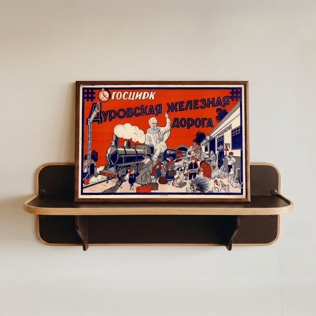 Framed art print of State Circus. The Durov railway, in a dark wood frame resting on a wall shelf
