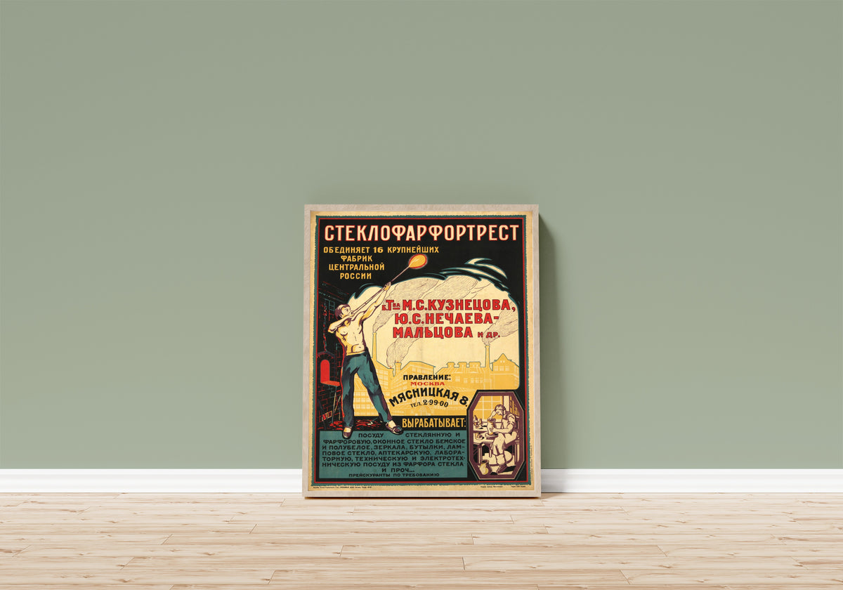 Framed art print of Steklofarfortrest, in a light wood frame leaning on a sage green wall above a wooden floor
