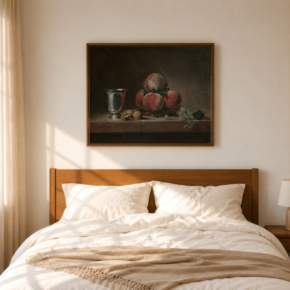 Framed art print of Still Life with Peaches, a Silver Goblet, Grapes, and Walnuts by Jean-Siméon Chardin, in a slim wood frame above a bed in a sunlit bedroom