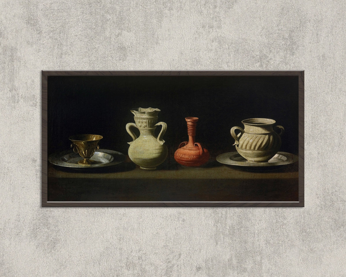 Framed art print of Still Life with Vessels by Francisco de Zurbarán, in a wide black frame on a concrete wall