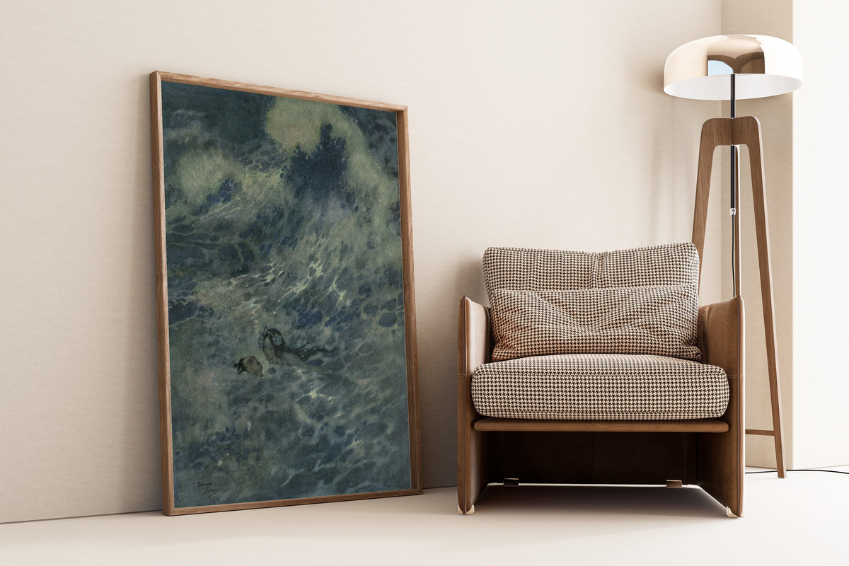 Framed art print of Stories from Hans Andersen: The Little Mermaid to the Rescue by Edmund Dulac, leaning against a wall beside an armchair and a floor lamp