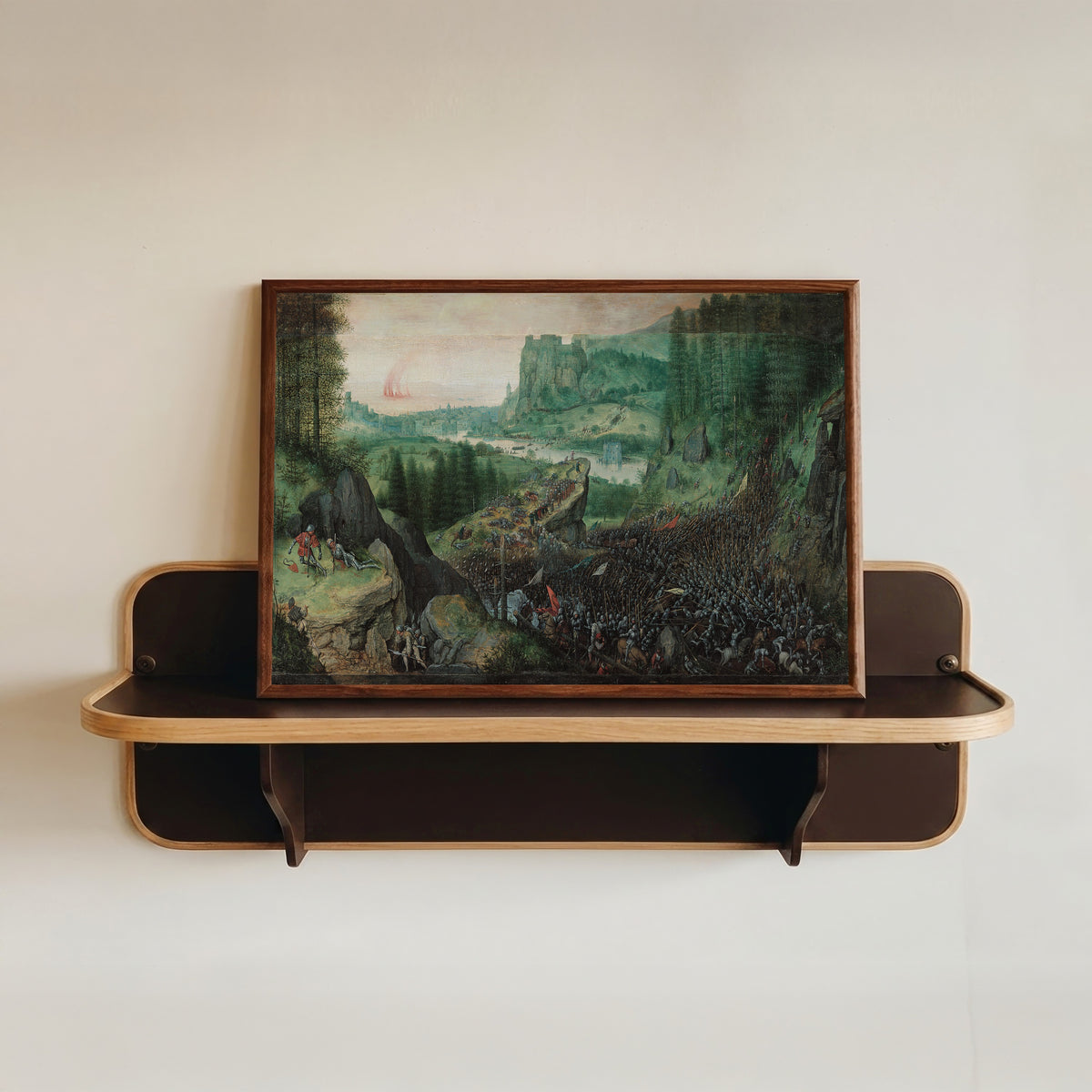 Framed art print of Suicide of Saul by Pieter Bruegel the Elder, in a dark wood frame resting on a wall shelf