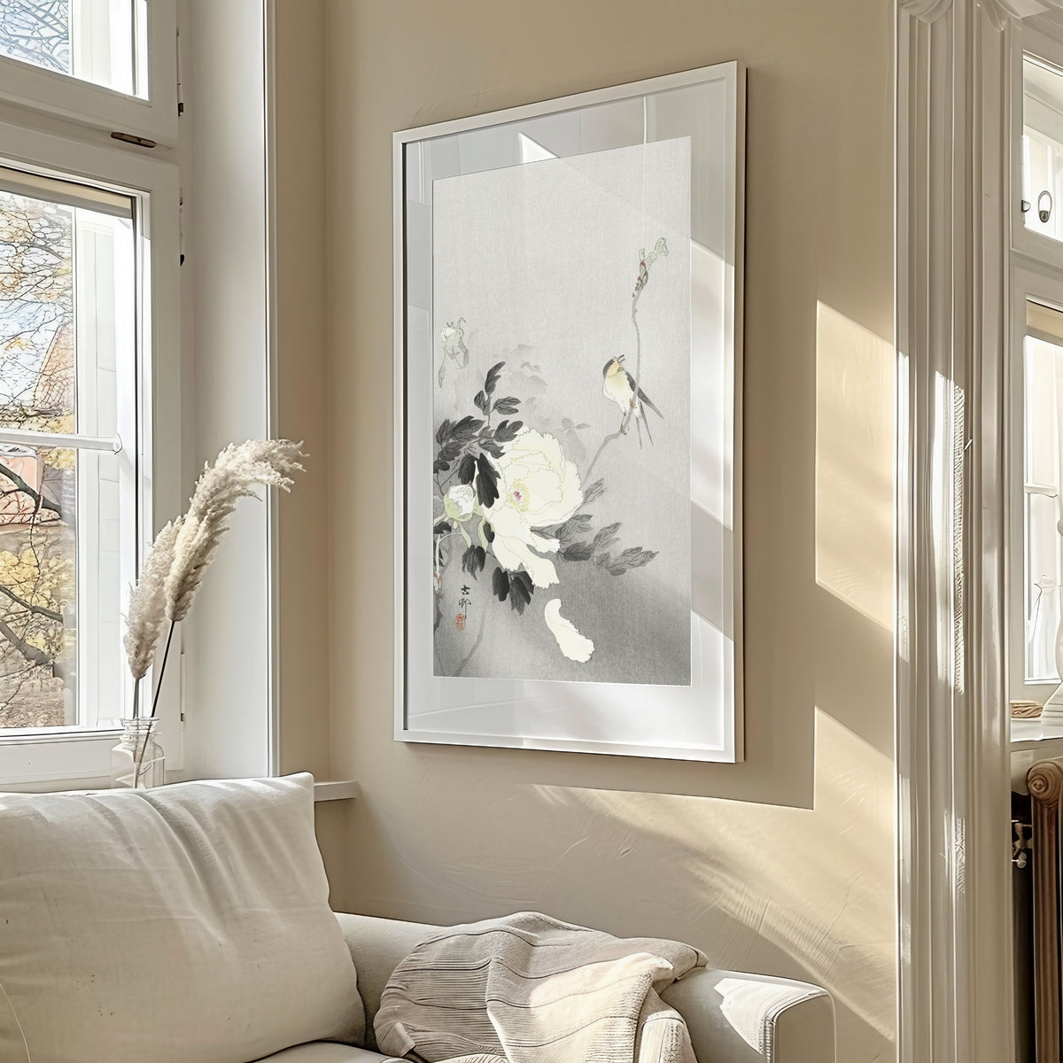 Framed art print of Swallow with Peony by Ohara Koson, in a sunlit living room above a sofa