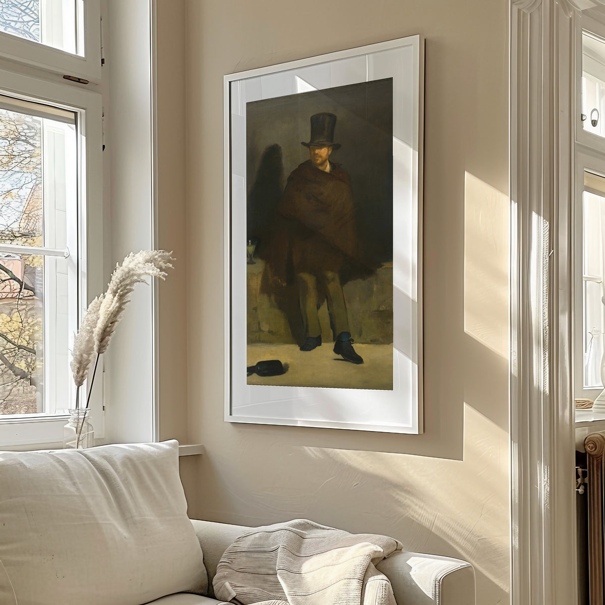 Framed art print of The Absinthe Drinker by Édouard Manet, in a sunlit living room above a sofa