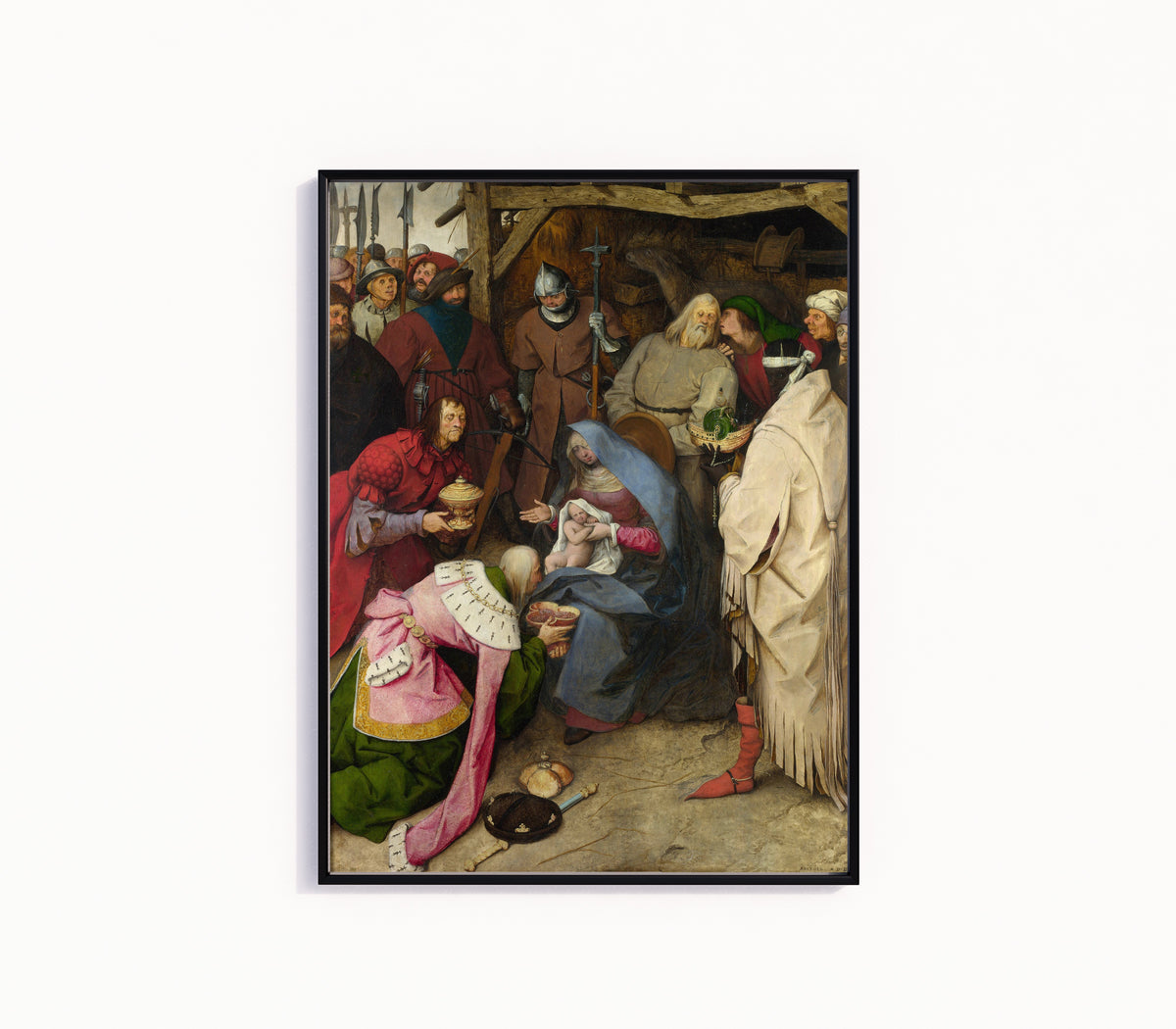 Framed art print of The Adoration of the Kings by Pieter Bruegel the Elder, in a slim black frame on a plain white wall