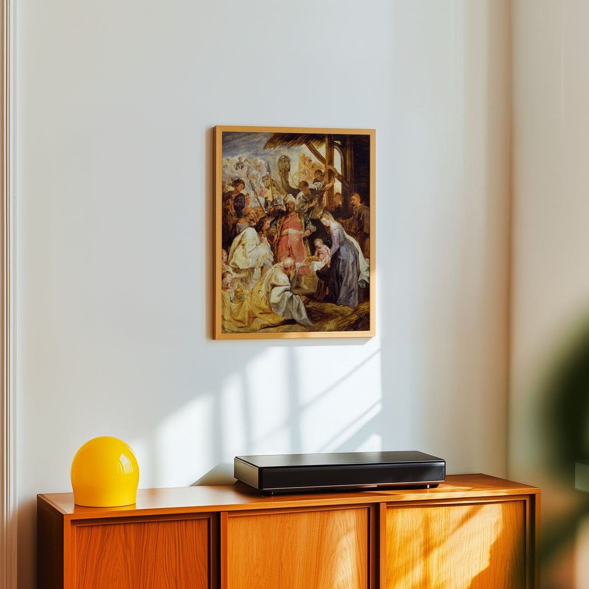 Framed art print of The Adoration of the Magi by Peter Paul Rubens, in a light wood frame on a white wall above an orange sideboard