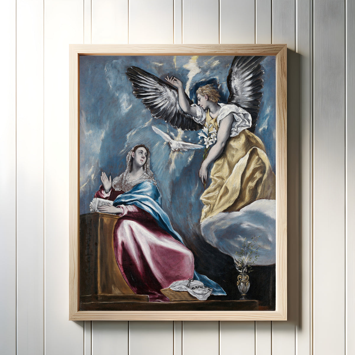 Framed art print of The Annunciation by El Greco, in a light wood frame on a white panelled wall