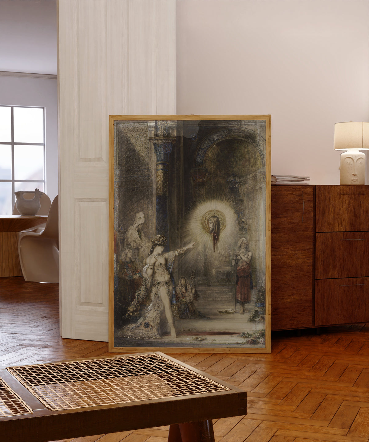 Framed art print of The Apparition by Gustave Moreau, in a light wood frame leaning in a warm room with a parquet floor