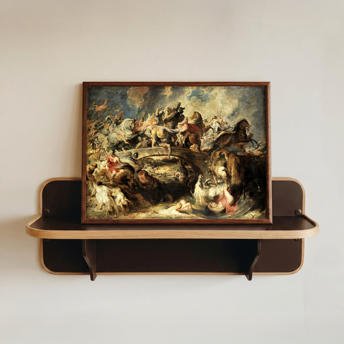 Framed art print of The Battle of the Amazons by Peter Paul Rubens, in a dark wood frame resting on a wall shelf