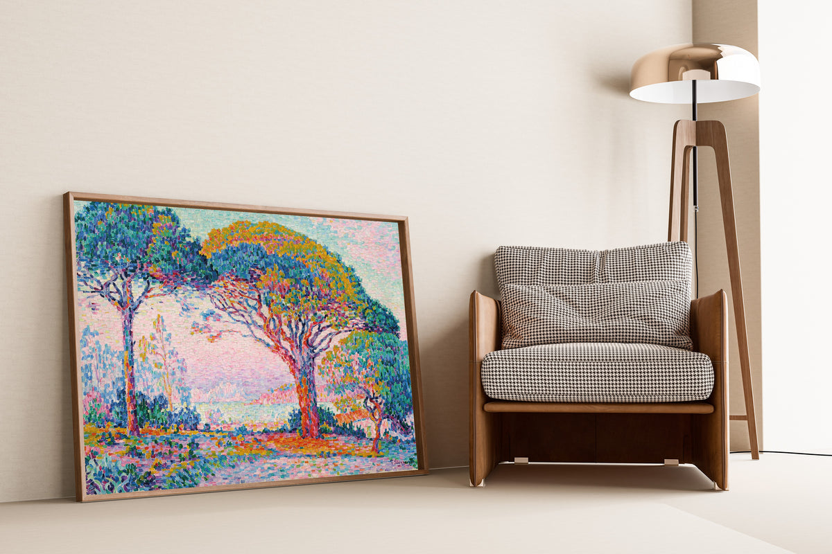Framed art print of The Bay, Saint-Tropez by Paul Signac, leaning against a wall beside an armchair and a floor lamp