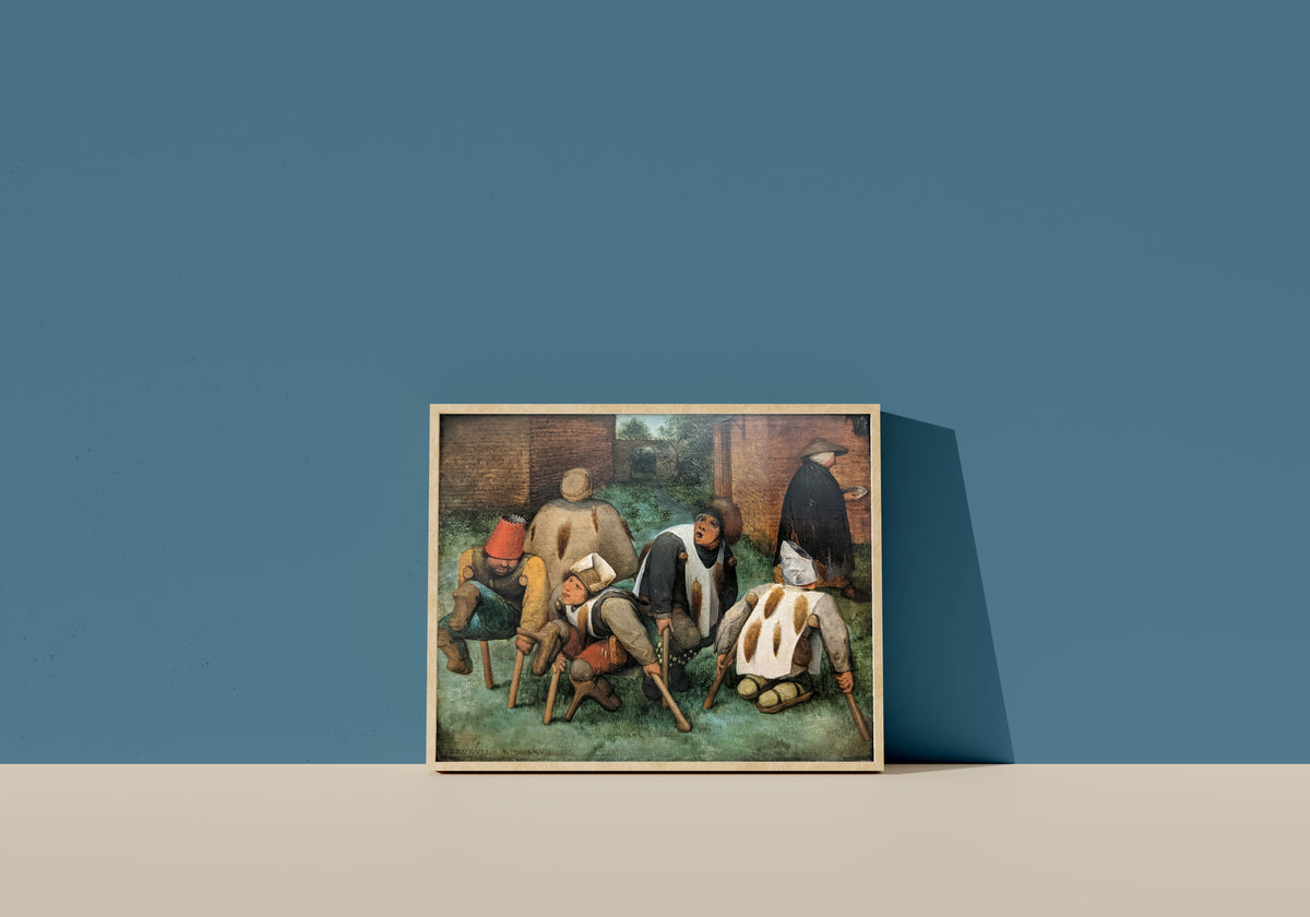 Framed art print of The Beggars by Pieter Bruegel the Elder, in a light wood frame leaning on a blue wall