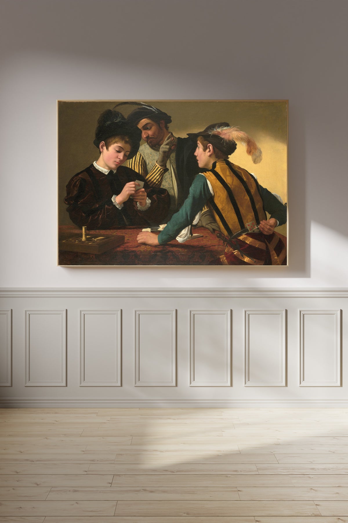 Framed art print of The Cardsharps by Caravaggio, on a panelled wall in afternoon light