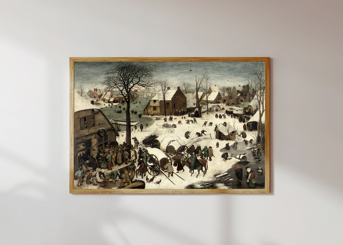 Framed art print of The Census at Bethlehem by Pieter Bruegel the Elder, in a light wood frame on a sunlit white wall