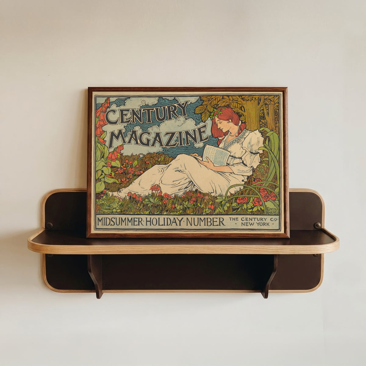 Framed art print of The Century Magazine, Midsummer Holiday Number by Louis Rhead, in a dark wood frame resting on a wall shelf
