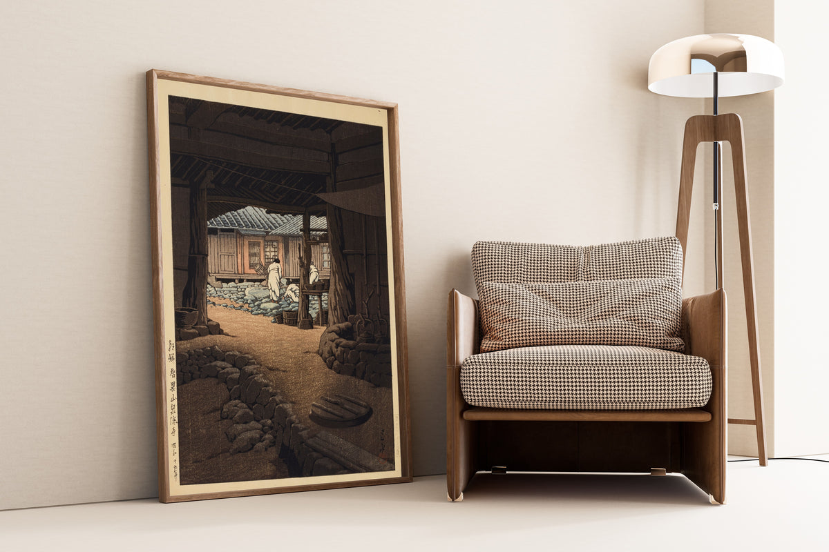Framed art print of The Cheoneunsa Temple, Mount Jirisan, Korea by Kawase Hasui, leaning against a wall beside an armchair and a floor lamp