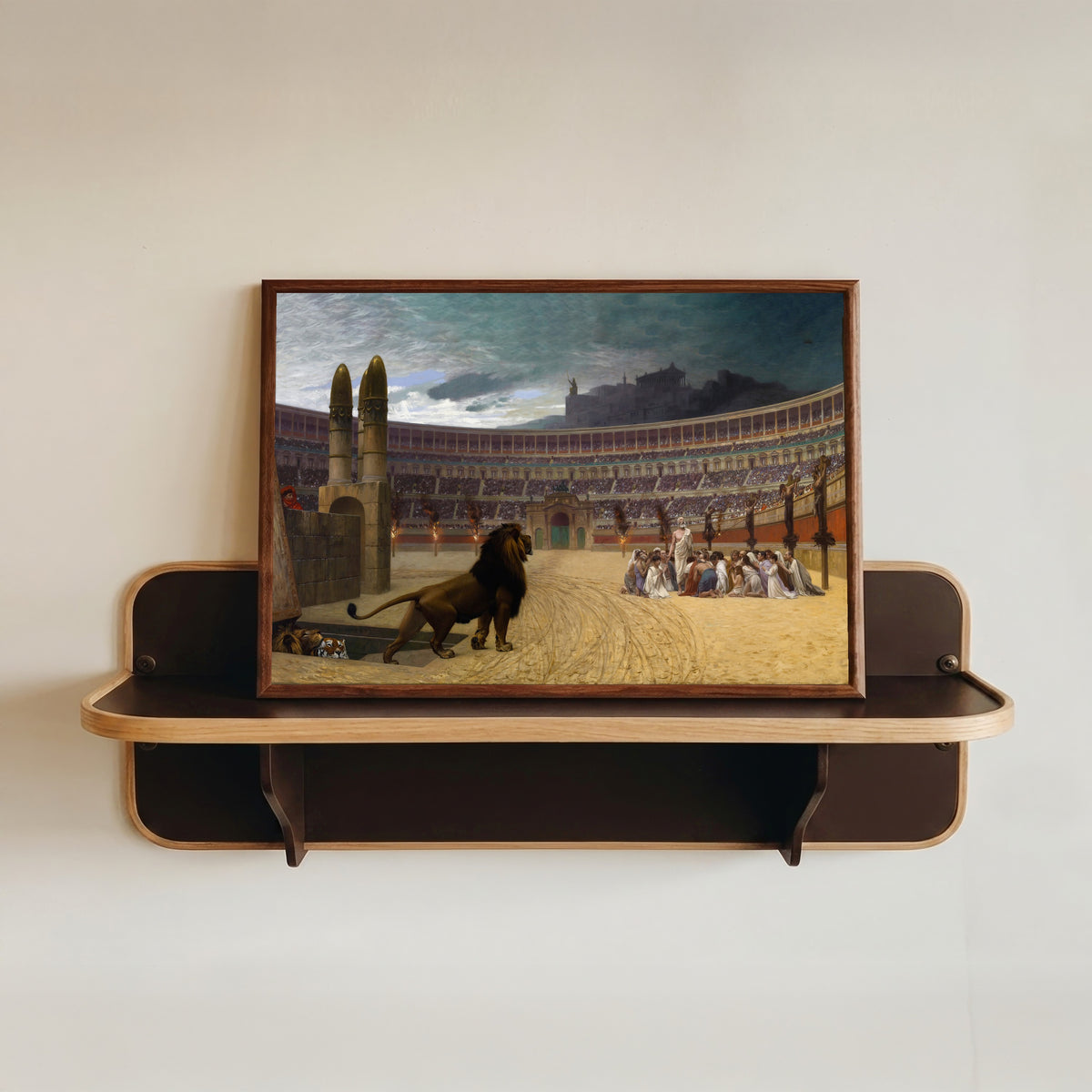 Framed art print of The Christian Martyrs' Last Prayer by Jean-Léon Gérôme, in a dark wood frame resting on a wall shelf