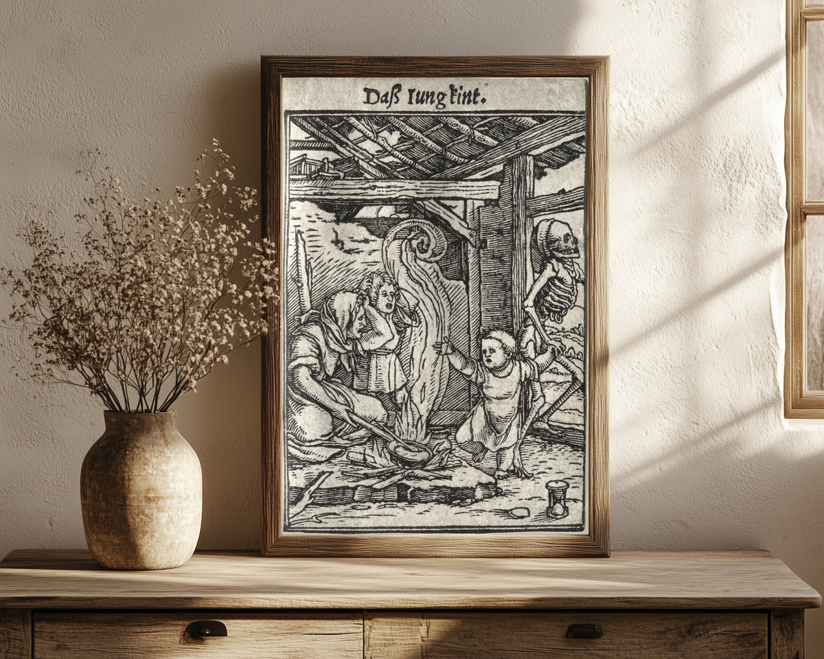Framed art print of The Dance of Death: Daß Iung kint (The… by Hans Holbein the Younger, in a dark wood frame leaning on a rustic console beside dried flowers