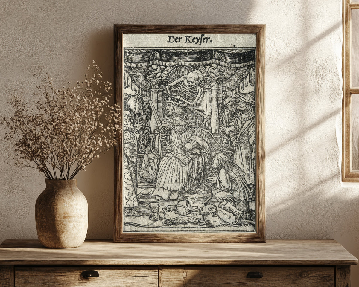 Framed art print of The Dance of Death: Der Keyser (The… by Hans Holbein the Younger, in a dark wood frame leaning on a rustic console beside dried flowers