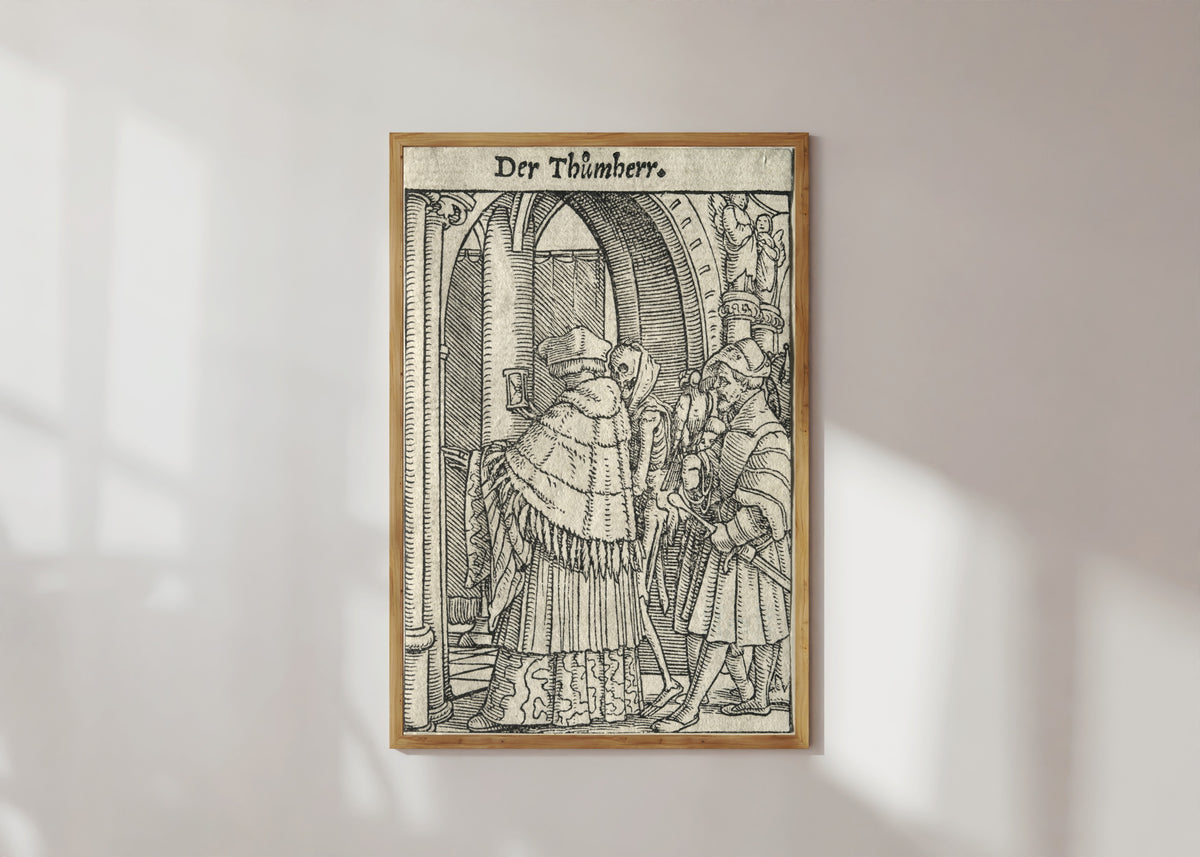 Framed art print of The Dance of Death: Der Thůmherr (The Canon) by Hans Holbein the Younger, in a light wood frame on a sunlit white wall