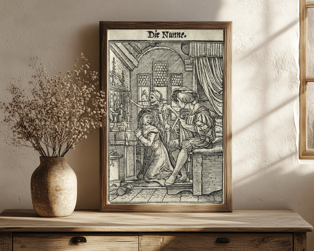 Framed art print of The Dance of Death: Die Nunne (The Nun) by Hans Holbein the Younger, in a dark wood frame leaning on a rustic console beside dried flowers