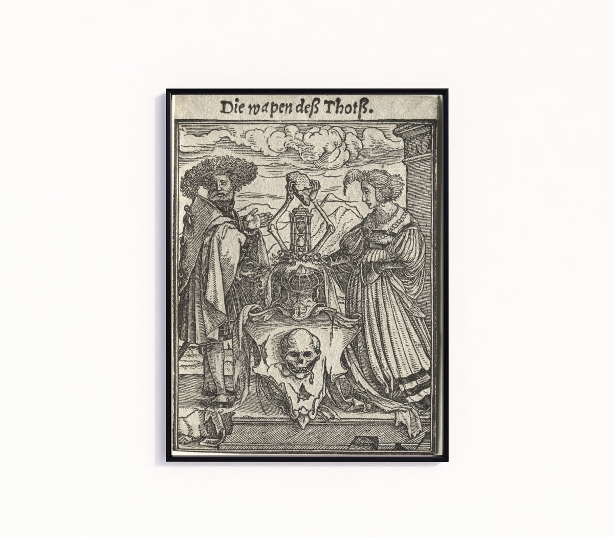 Framed art print of The Dance of Death: Die wapen deß Thotß (The Coat of Arms of Death) by Hans Holbein the Younger, in a slim black frame on a plain white wall