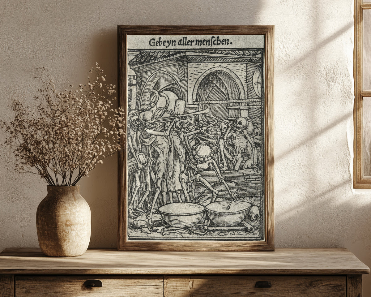 Framed art print of The Dance of Death: Gebeyn aller… by Hans Holbein the Younger, in a dark wood frame leaning on a rustic console beside dried flowers