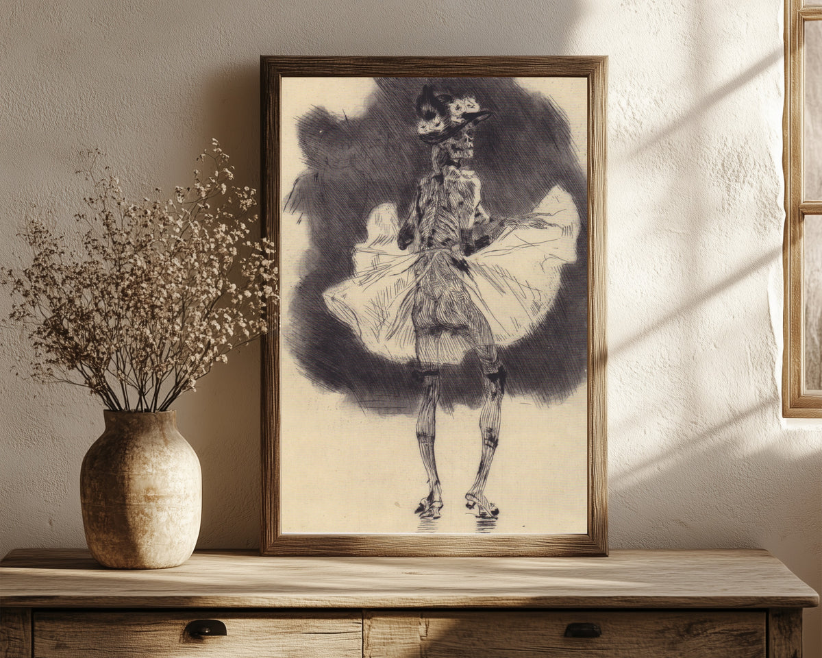 Framed art print of The Dance of Death by Félicien Rops, in a dark wood frame leaning on a rustic console beside dried flowers