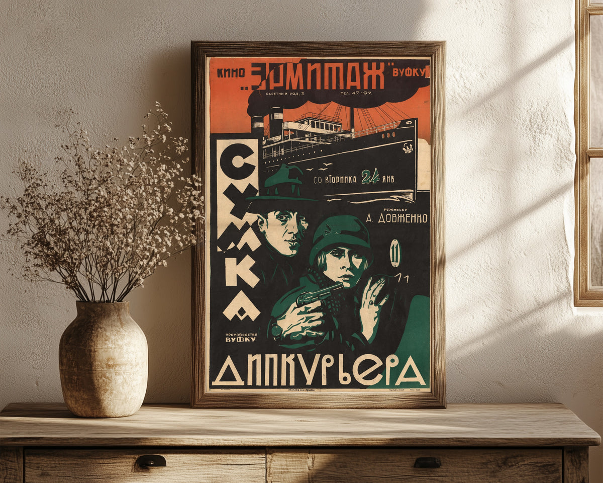 Framed art print of The Diplomatic Pouch, in a dark wood frame leaning on a rustic console beside dried flowers