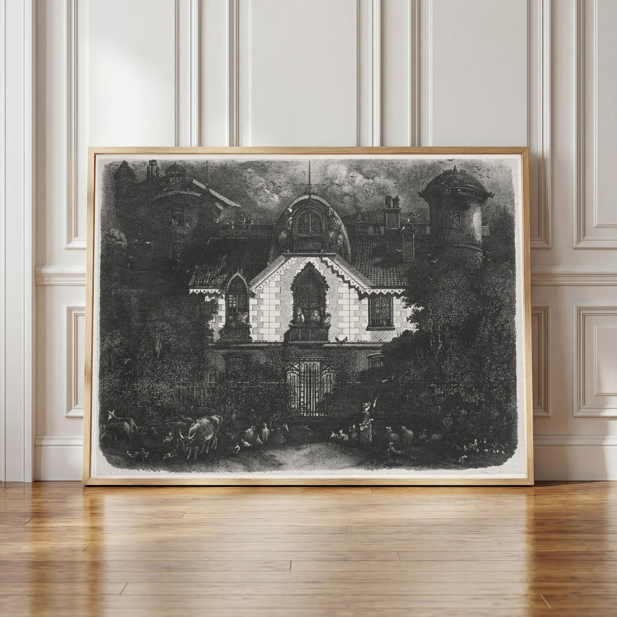 Framed art print of The Enchanted House by Rodolphe Bresdin, in a light wood frame leaning against a panelled white wall