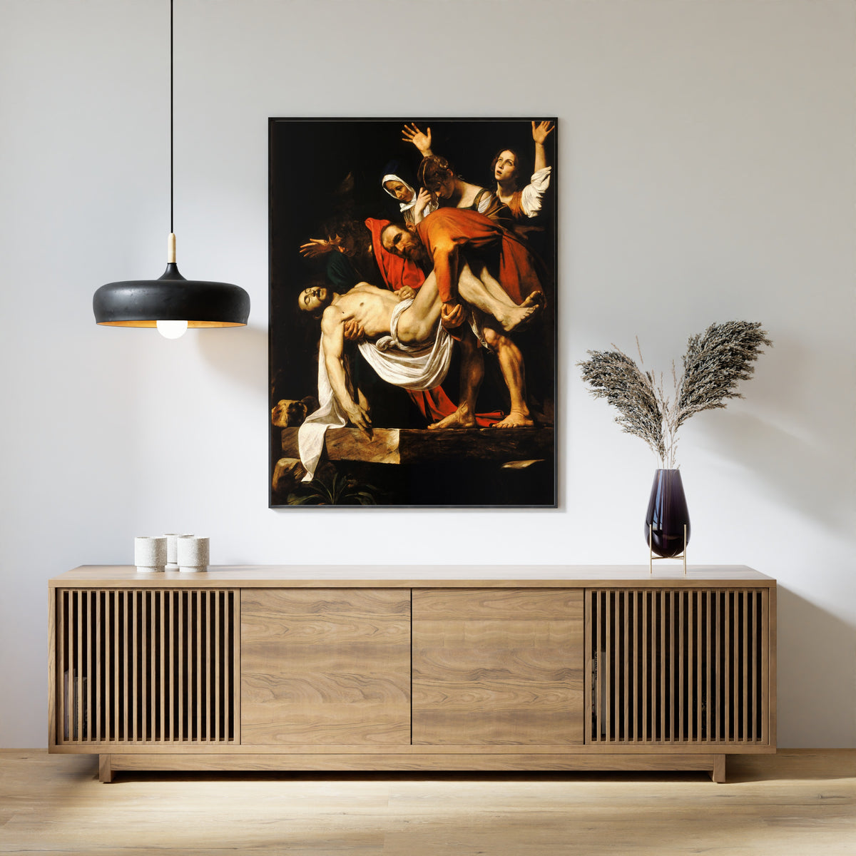 Framed art print of The Entombment of Christ by Caravaggio, above a slatted wood sideboard