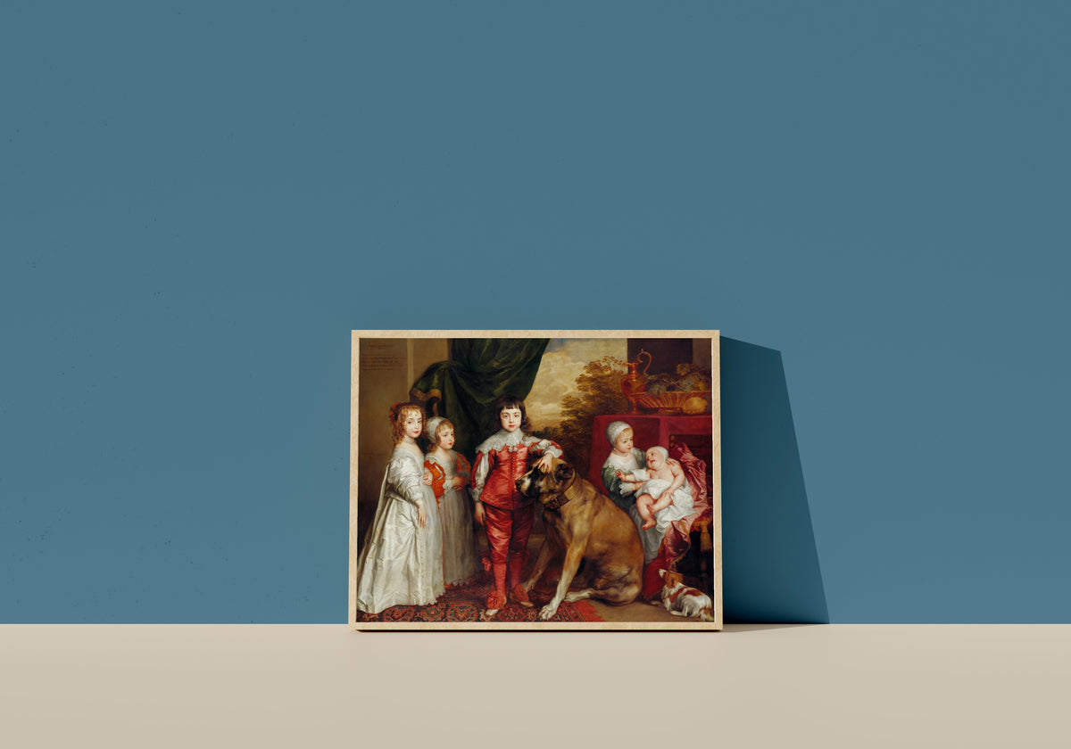Framed art print of The Five Eldest Children of Charles I by Anthony van Dyck, in a light wood frame leaning on a blue wall