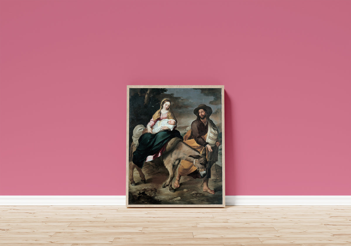 Framed art print of The Flight into Egypt by Bartolomé Esteban Murillo, in a light wood frame leaning on a pink wall above a wooden floor