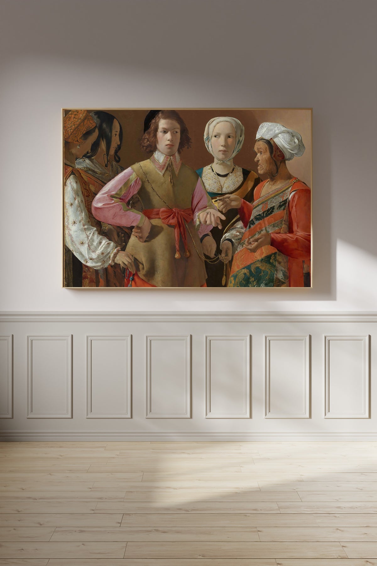Framed art print of The Fortune-Teller by Georges de La Tour, on a panelled wall in afternoon light