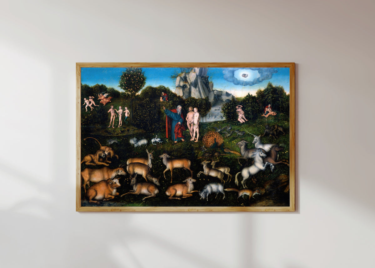 Framed art print of The Garden of Eden by Lucas Cranach the Elder, in a light wood frame on a sunlit white wall