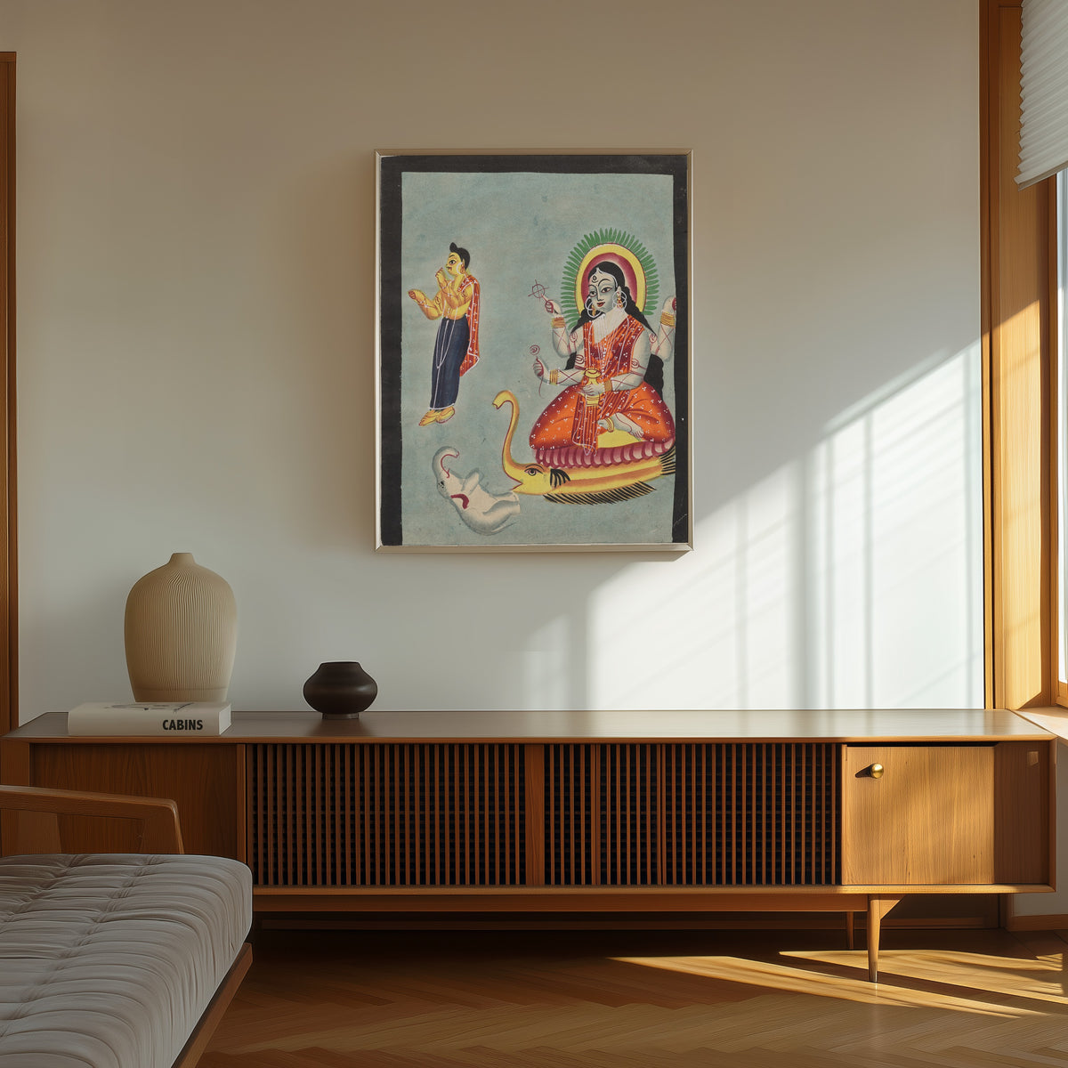 Framed art print of The Goddess Ganga, from a Kalighat album by Kalighat painter, in a thin light frame on a sunlit wall above a wooden sideboard