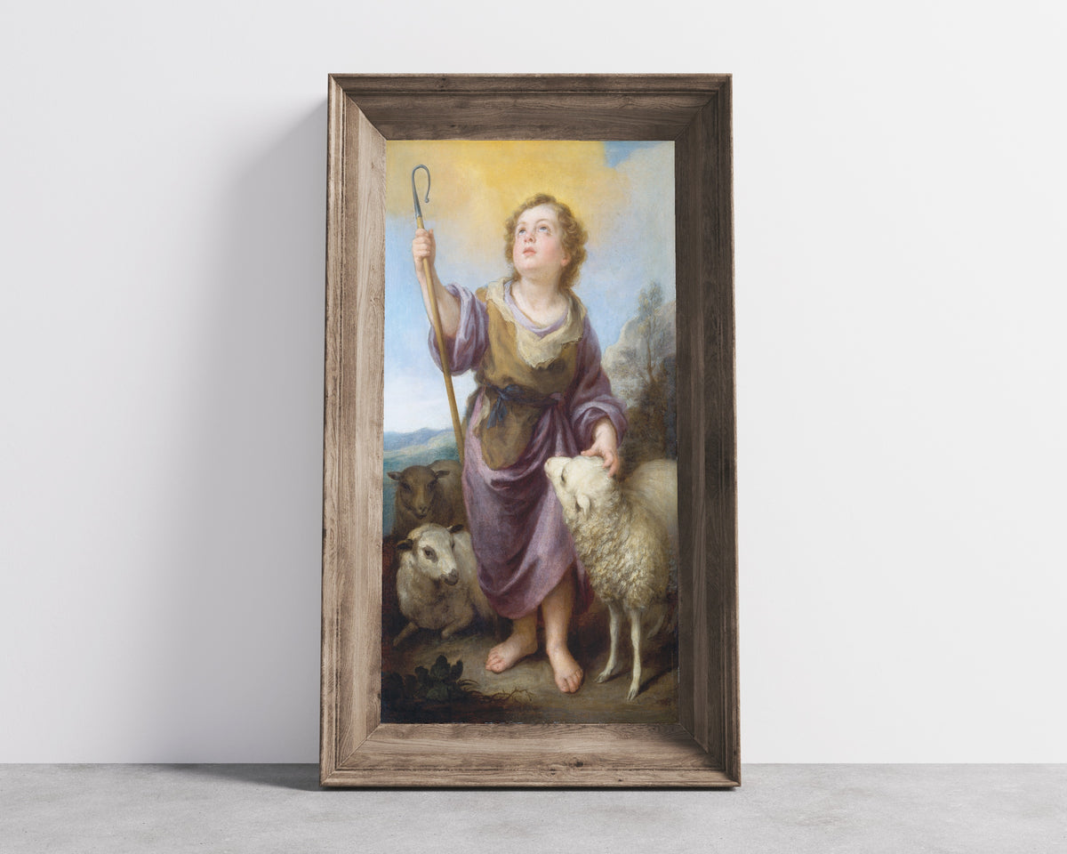 Framed art print of The Good Shepherd by Bartolomé Esteban Murillo, in a wide wooden frame leaning against a concrete wall